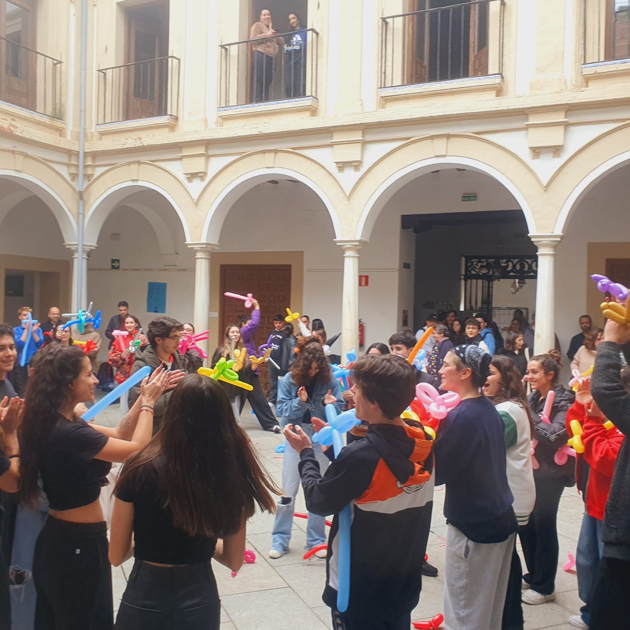Dia de la mujer en la ESAD 03 Estudiantes y profesorado de la ESAD de Córdoba celebran el Día Internacional de la Mujer en el patio de la escuela, participando en una actividad lúdica con globos y aplausos en un ambiente de alegría y compañerismo.